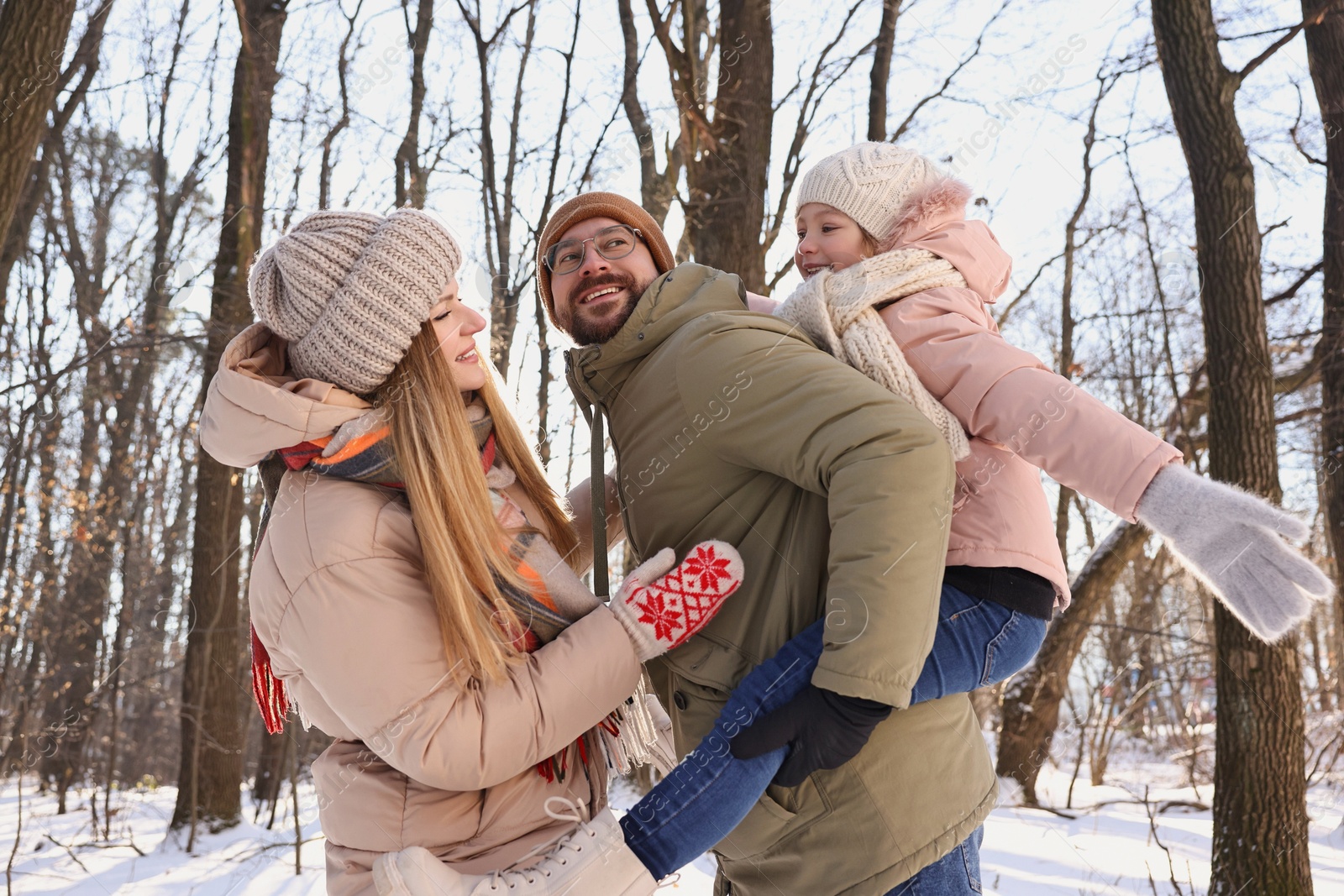 Photo of Happy family spending time together in snowy forest