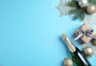 Photo of Creative flat lay composition with bottle of champagne and Christmas decorations on color background. Space for text