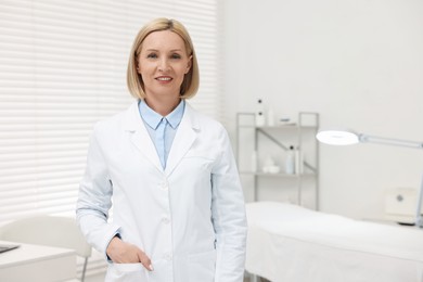 Portrait of happy dermatologist in modern clinic, space for text