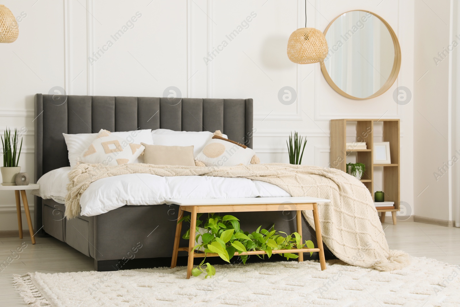 Photo of Stylish bedroom interior with large comfortable bed and mirror