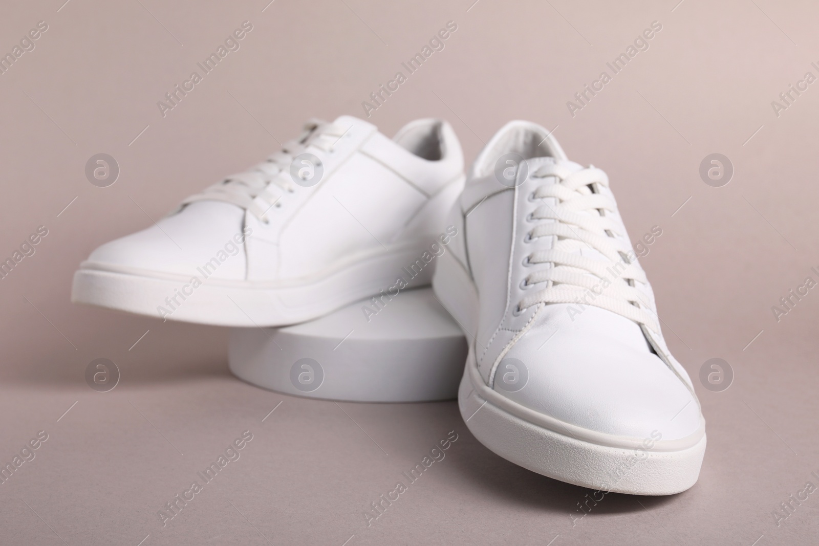 Photo of Pair of stylish white sneakers on grey background