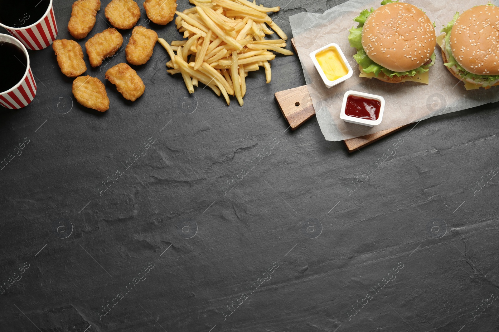 Photo of Flat lay composition with delicious fast food menu on black table. Space for text