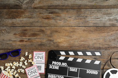 Flat lay composition with clapperboard, cinema tickets and 3d glasses on wooden table, space for text
