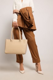 Young woman with stylish bag on white background, closeup