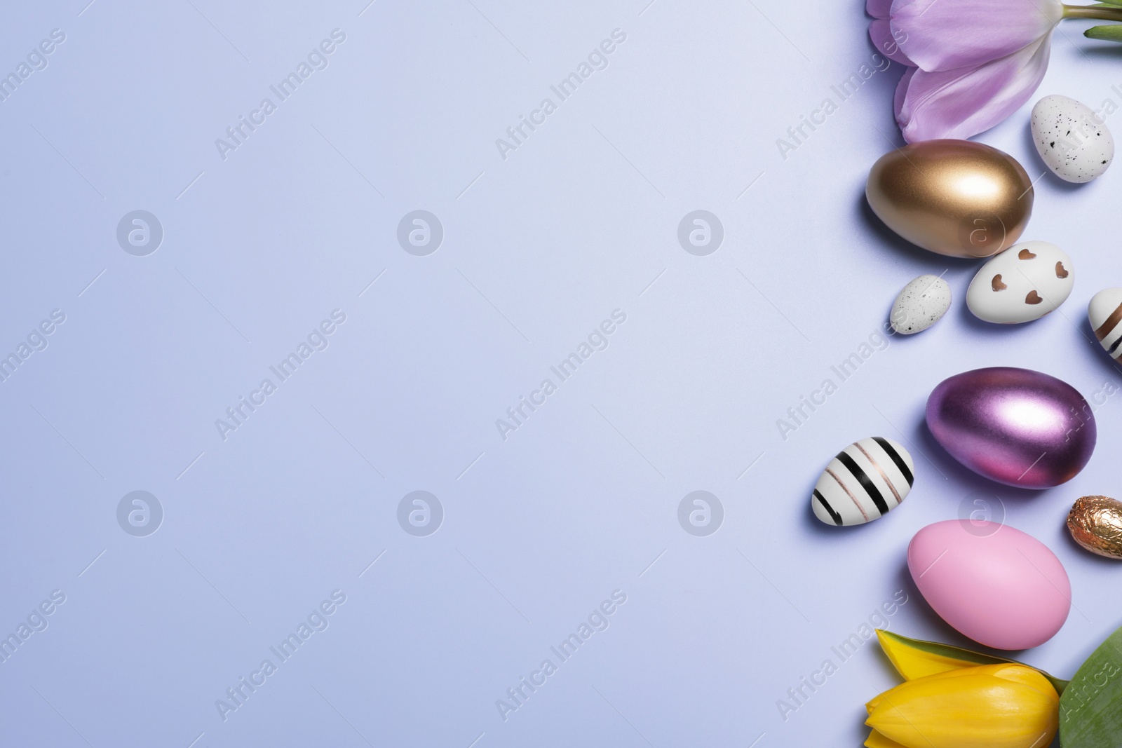 Photo of Flat lay composition with festively decorated Easter eggs and beautiful tulips on pale light blue violet background. Space for text