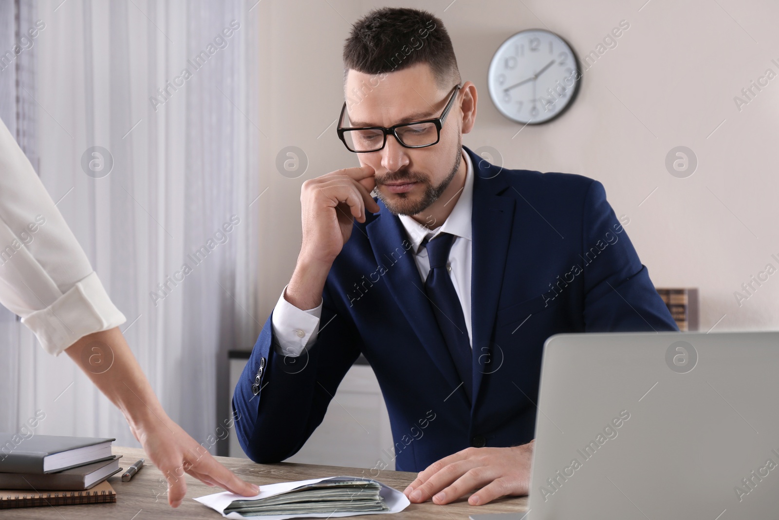 Photo of Woman offering bribe to man at table in office