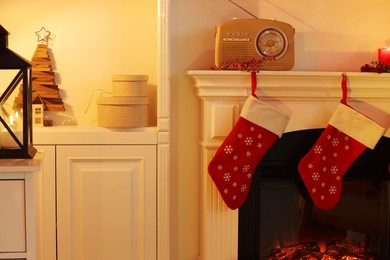 Photo of Fireplace and Christmas decor in cozy room. Interior design