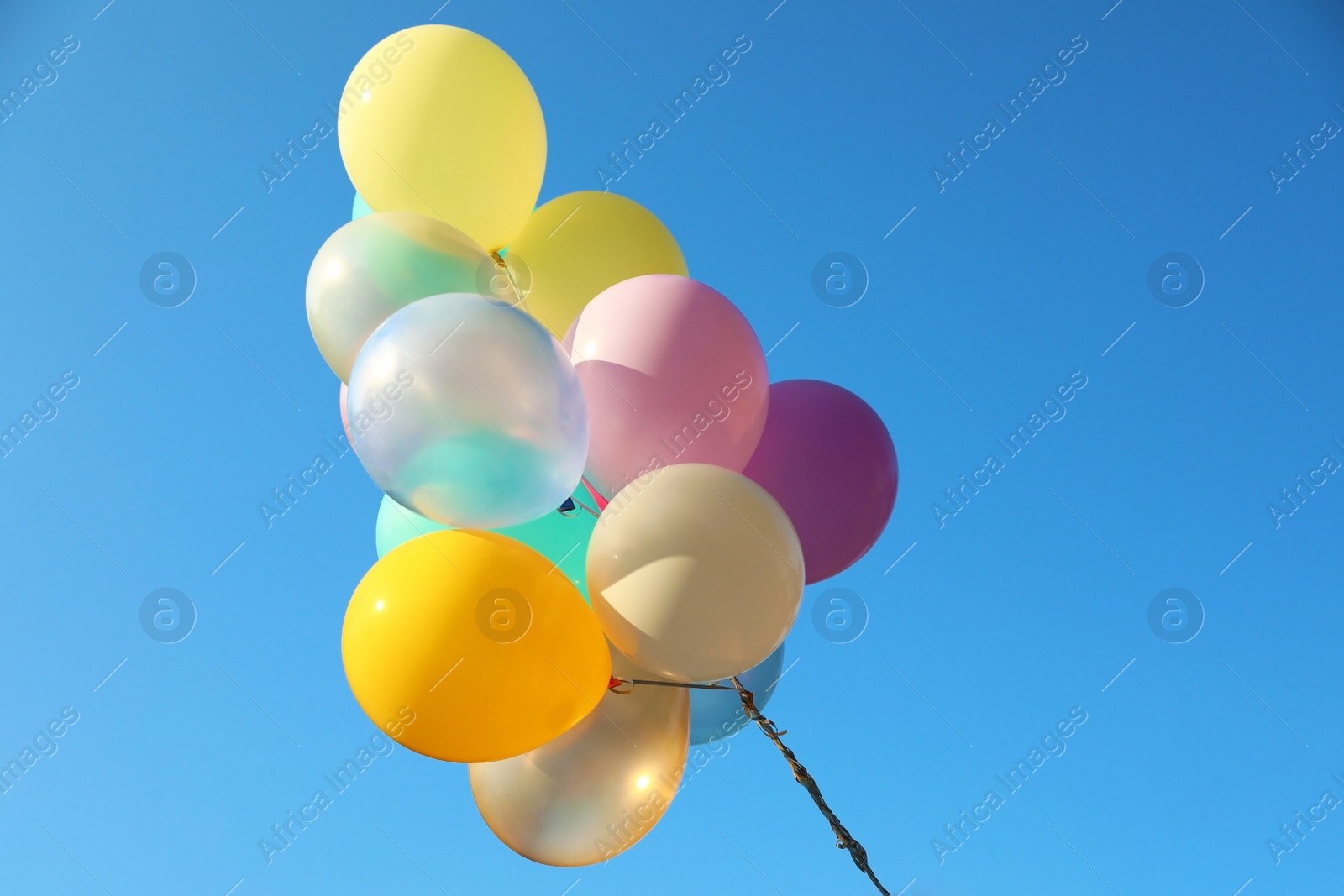 Image of Many sunlit bright balloons in blue sky