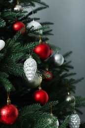 Photo of Beautifully decorated Christmas tree on grey background, closeup