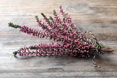 Bunch of heather branches with beautiful flowers on wooden table