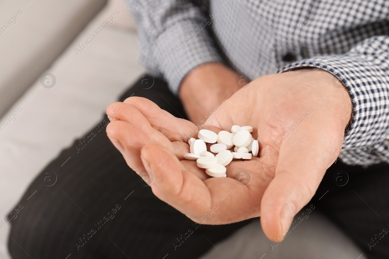 Photo of Senior man holding pills in hand, closeup