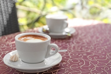 Cup of delicious aromatic coffee on table