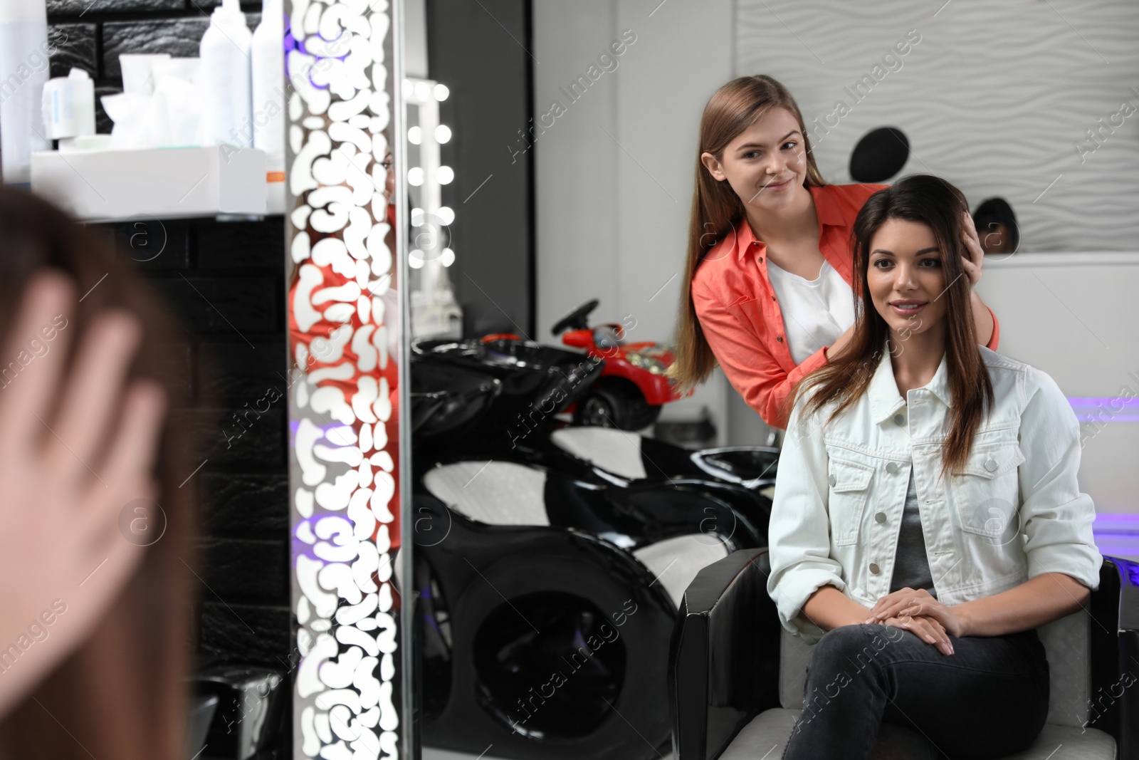 Photo of Professional hairdresser working with client in beauty salon