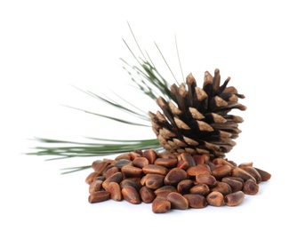 Photo of Heap of pine nuts and cone on white background