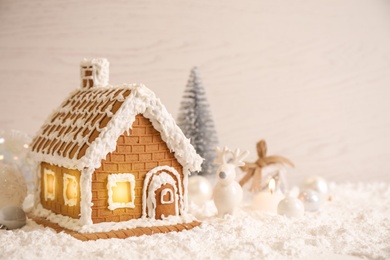 Photo of Beautiful gingerbread house decorated with icing on snow, space for text