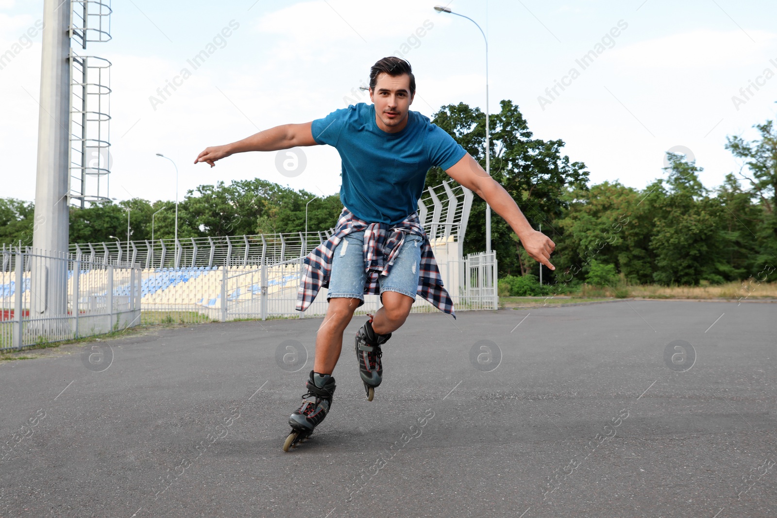 Photo of Handsome young man roller skating outdoors. Recreational activity