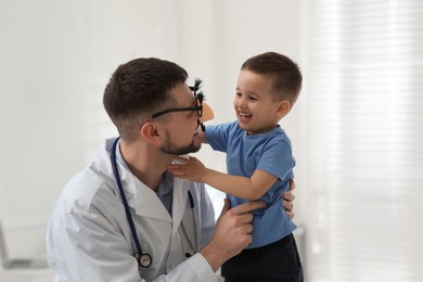 Pediatrician playing with little boy at hospital