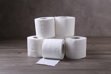 Photo of Soft toilet paper rolls on wooden table