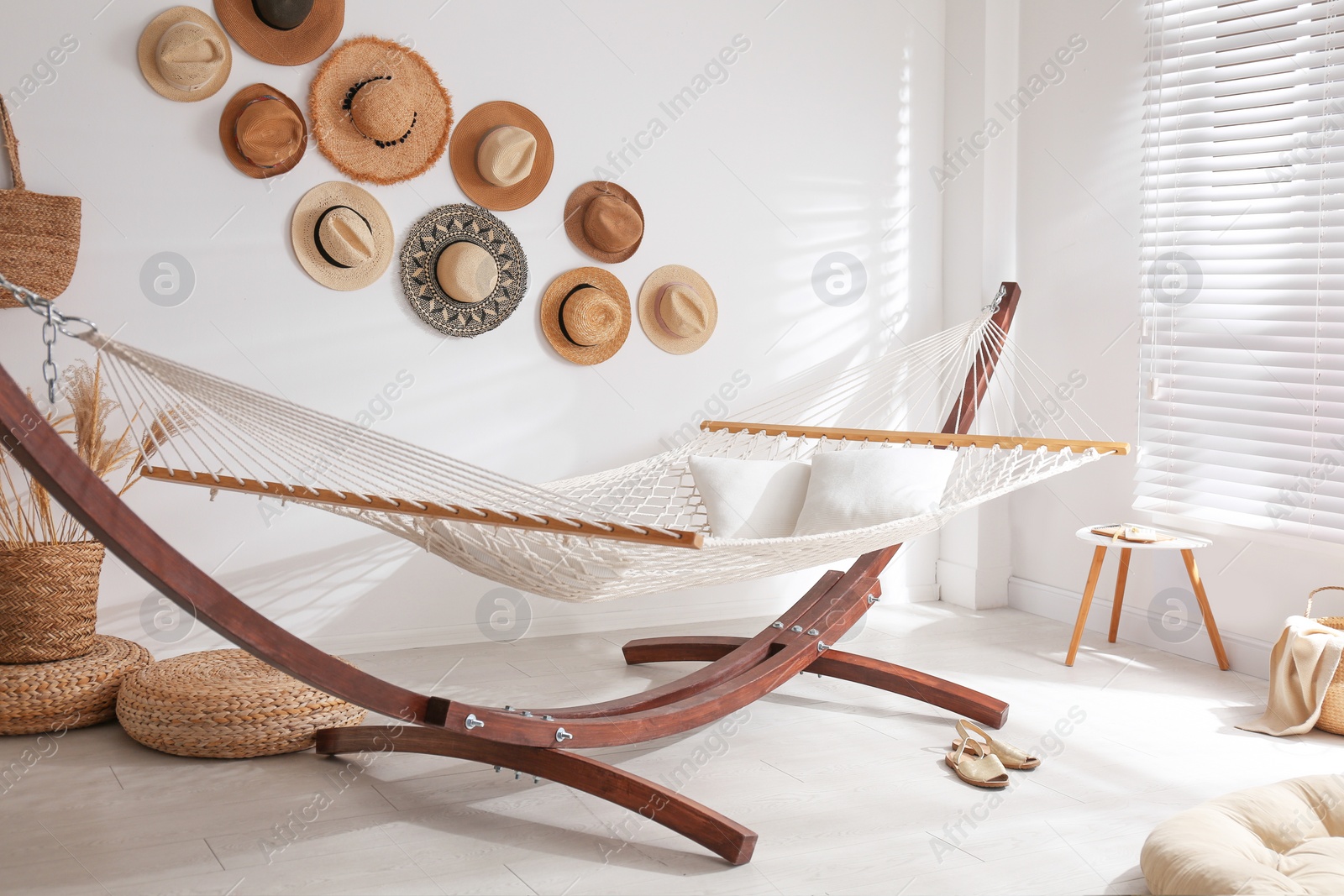 Photo of Comfortable hammock with pillows in stylish room. Interior design