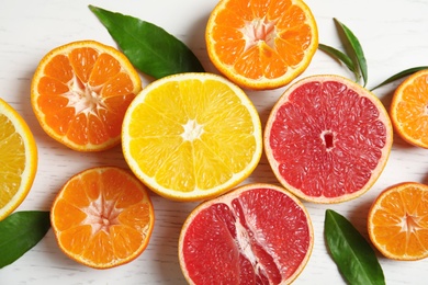 Photo of Different citrus fruits on wooden background, top view