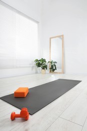 Photo of Exercise mat, yoga block and dumbbells at home
