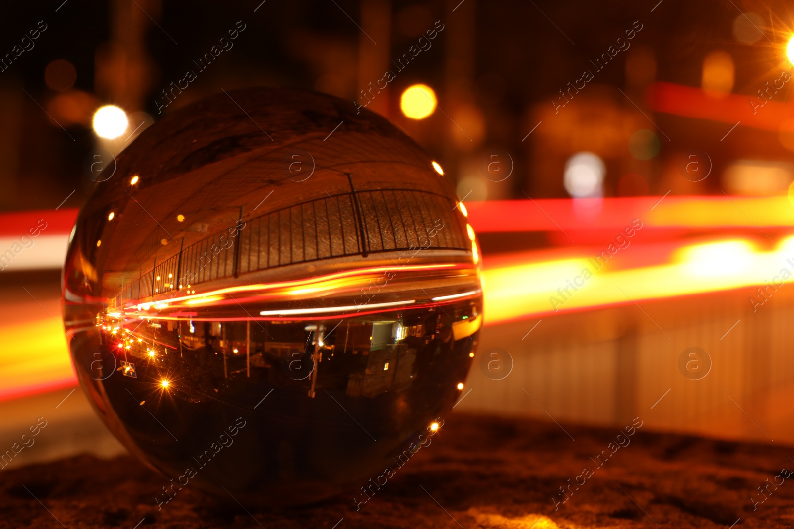 Photo of Beautiful city street, overturned reflection. Crystal ball at night, closeup. Space for text