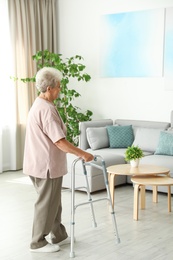 Photo of Elderly woman using walking frame at home