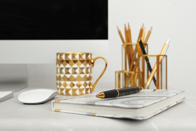Stylish workplace with different golden accessories indoors. Idea for interior design