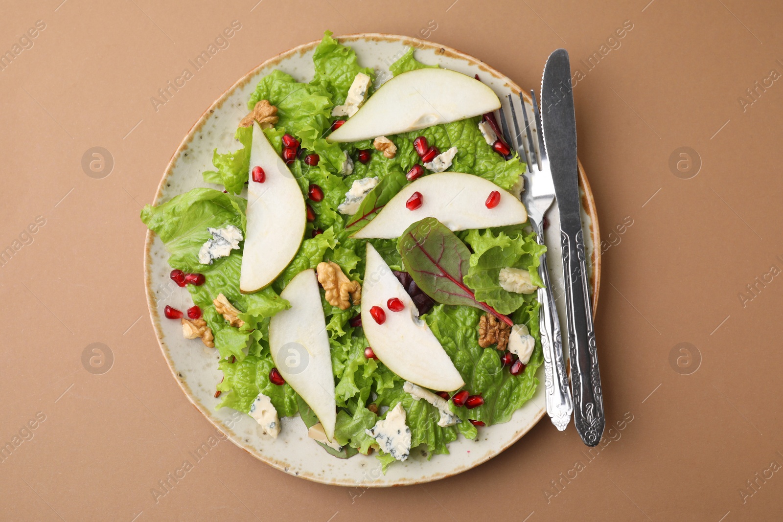 Photo of Delicious pear salad and cutlery on beige background, top view