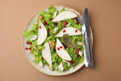 Photo of Delicious pear salad and cutlery on beige background, top view