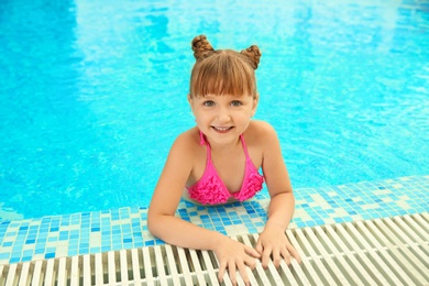 Photo of Happy girl resting in blue swimming pool