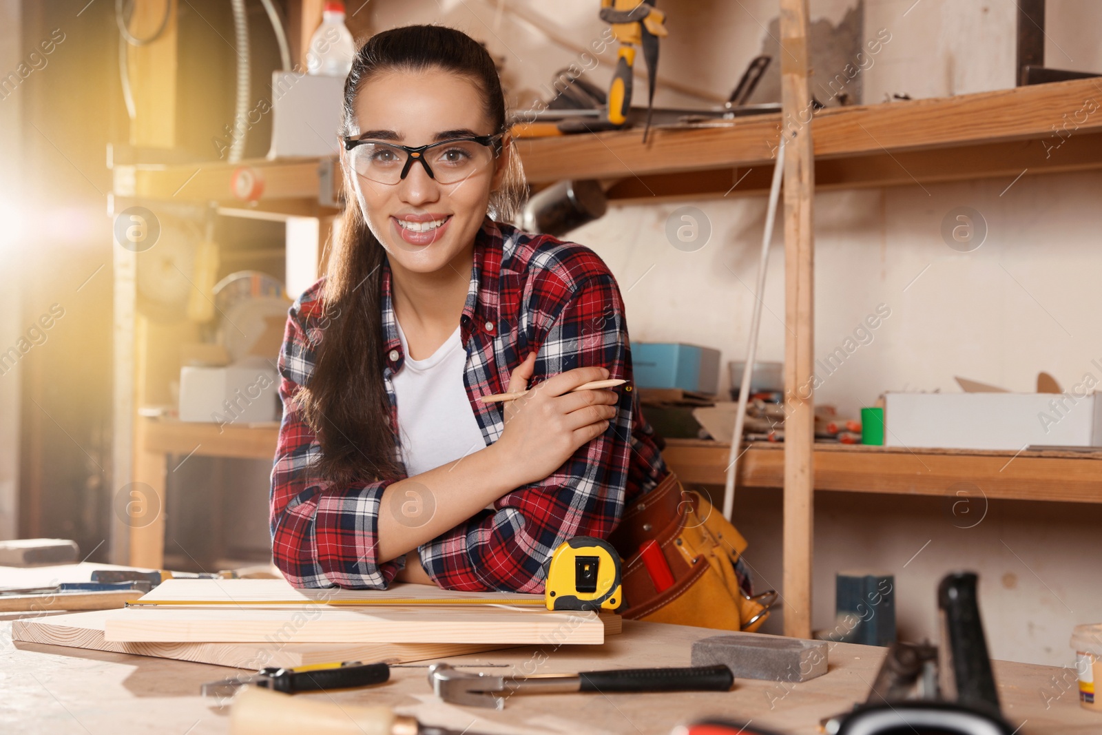 Photo of Female carpenter with wooden boards in workshop