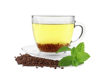 Cup of aromatic buckwheat tea, granules and mint on white background
