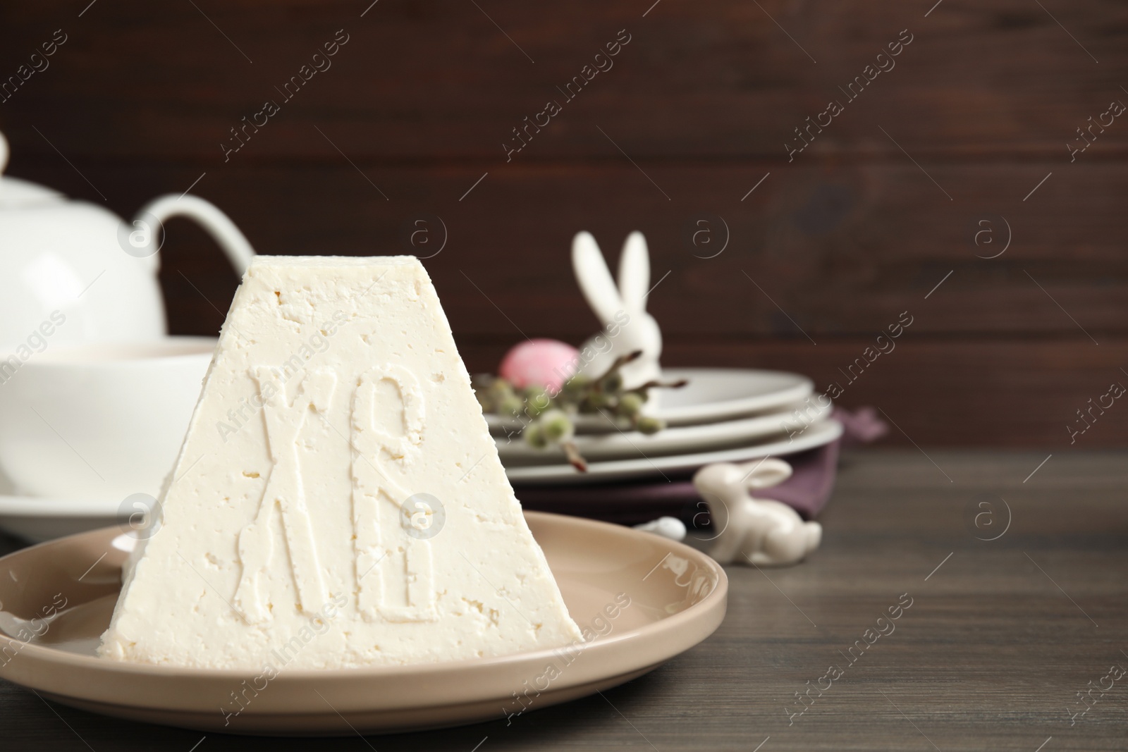 Photo of Traditional cottage cheese Easter paskha on wooden table, space for text