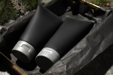 Photo of Gift box with men's cosmetic products in black tubes, closeup