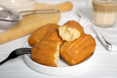 Photo of Delicious madeleine cakes on white wooden table, closeup