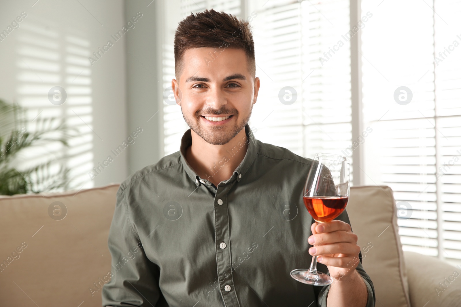 Photo of Man drinking wine while having online video conference at home, view from web camera. Social distancing during coronavirus pandemic