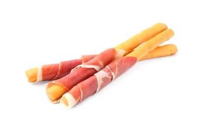 Delicious grissini sticks with prosciutto on white background