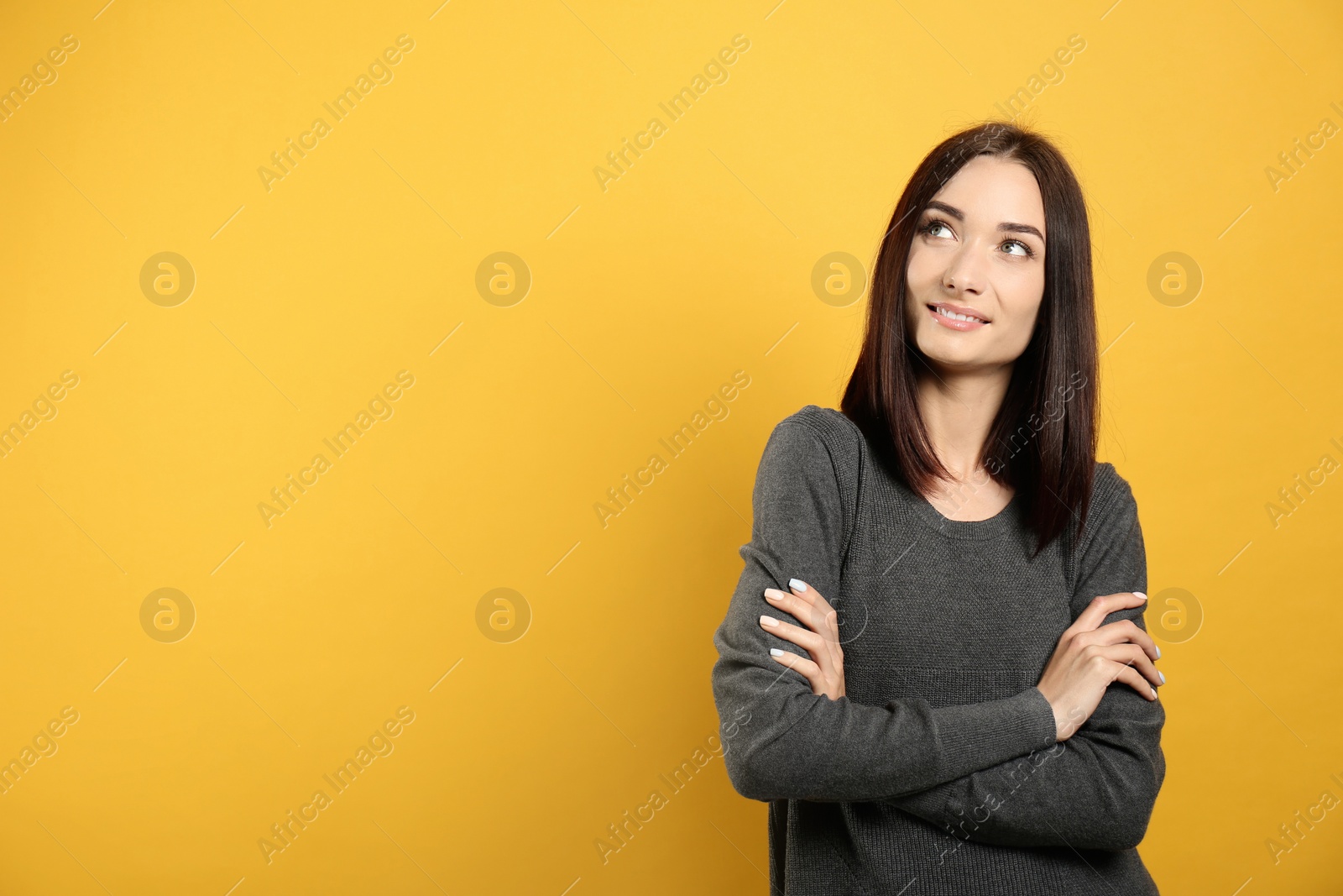 Photo of Portrait of pretty young woman with gorgeous chestnut hair and charming smile on yellow background, space for text