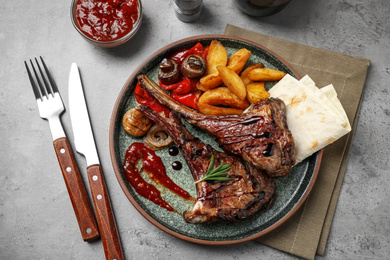 Delicious grilled ribs served on light grey table, flat lay