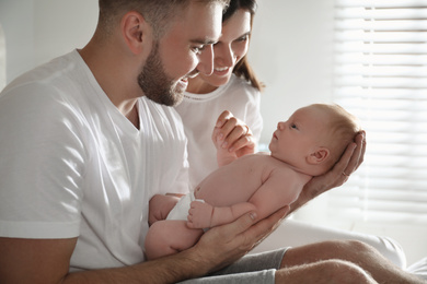 Happy couple with their newborn baby at home