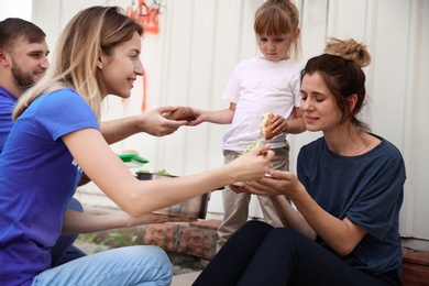 Photo of Poor people receiving food from volunteers outdoors