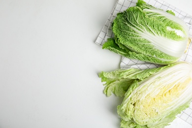 Photo of Fresh ripe Chinese cabbages on white table, top view. Space for text
