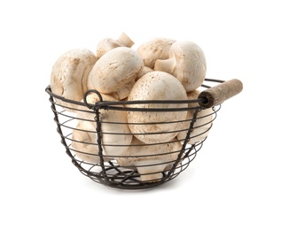 Basket with fresh raw champignon mushrooms on white background