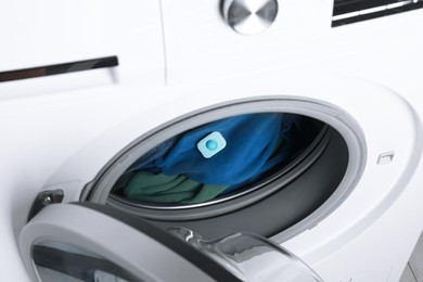 Photo of Water softener tablet on clothes in washing machine