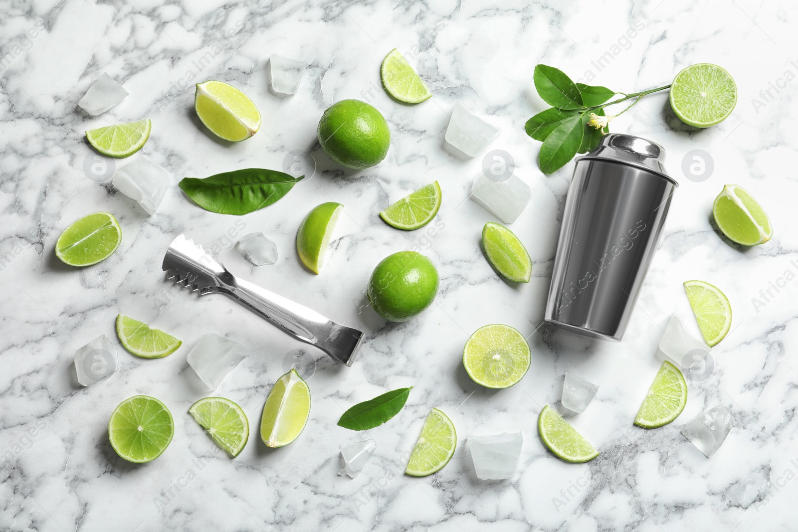 Photo of Flat lay composition with lime, mint and shaker on marble background. Refreshing beverage ingredients