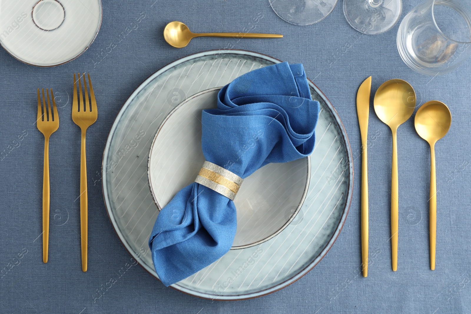 Photo of Stylish setting with cutlery, plates, napkin and glasses on table, flat lay