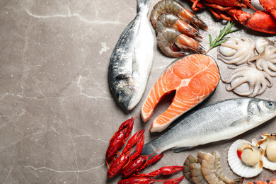 Photo of Fresh fish and seafood on marble table, flat lay