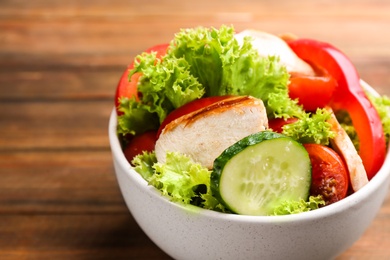 Delicious salad with chicken and vegetables on table, closeup