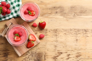 Delicious berry mousse with mint on wooden table, flat lay. Space for text